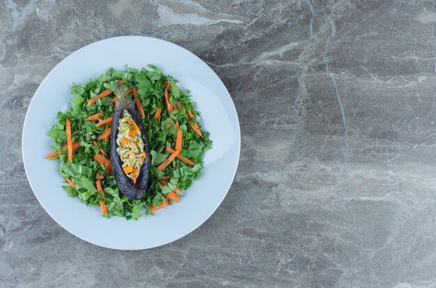 Riz aux aubergines sur l'assiette à salade, sur la table en marbre.