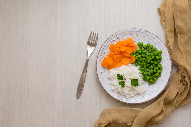 Riz aux légumes et au persil sur une assiette avec une fourchette