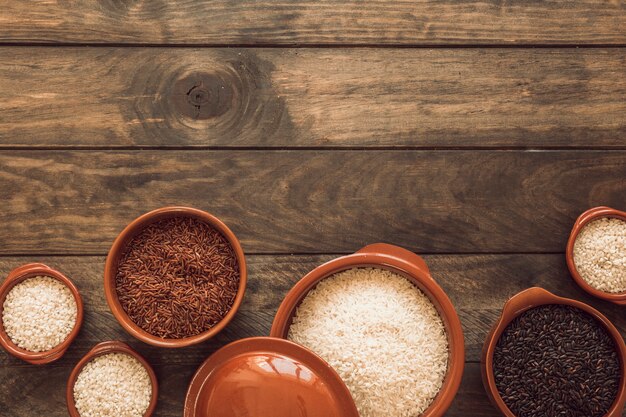 Riz complet au jasmin brun; riz blanc et riz biologique dans un bol sur une table en bois