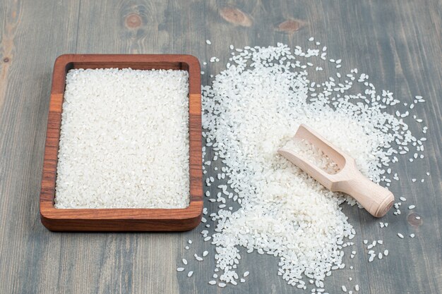 Riz cru sain avec une cuillère en bois sur une table en bois