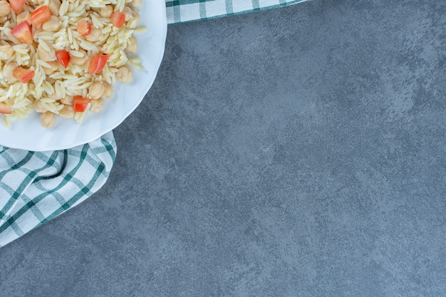 Photo gratuite riz cuit à la vapeur avec des pois et des tranches de tomates sur une assiette blanche.