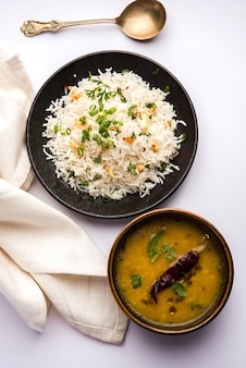 Riz frit à l'ail ou pulav à l'aide de riz basmati et de lahsun, servi avec dal tadka sur fond de mauvaise humeur, mise au point sélective