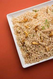 Riz frit à l'ail ou pulav à l'aide de riz basmati et de lahsun, servi avec dal tadka sur fond de mauvaise humeur, mise au point sélective