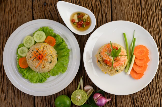 Riz frit aux crevettes sur une plaque blanche sur une table en bois