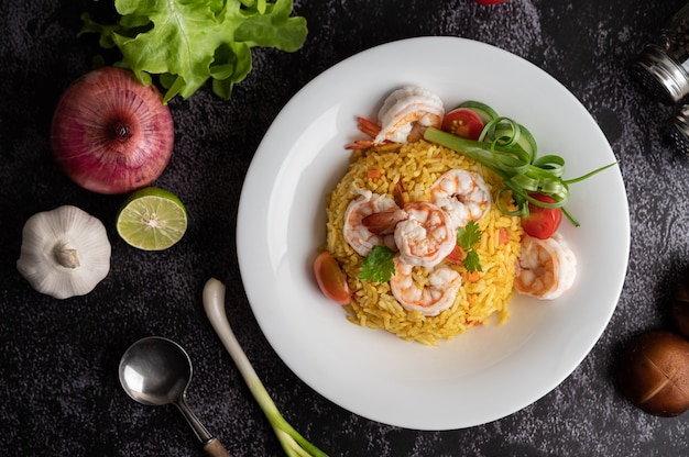 Riz frit aux crevettes avec tomates, carottes et oignons verts dans l'assiette