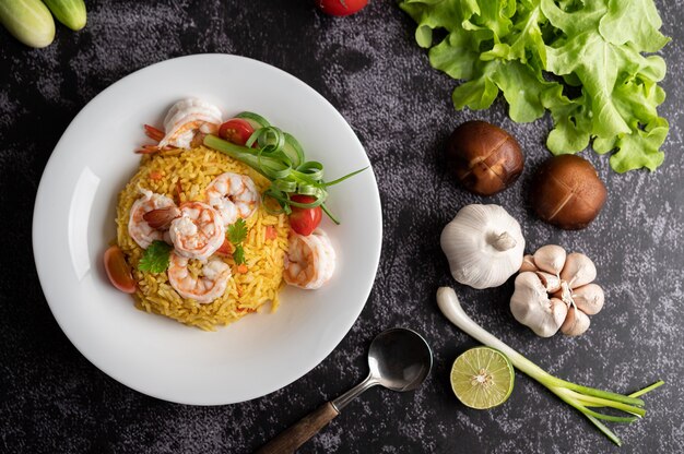 Riz frit aux crevettes avec tomates, carottes et oignons verts dans l'assiette