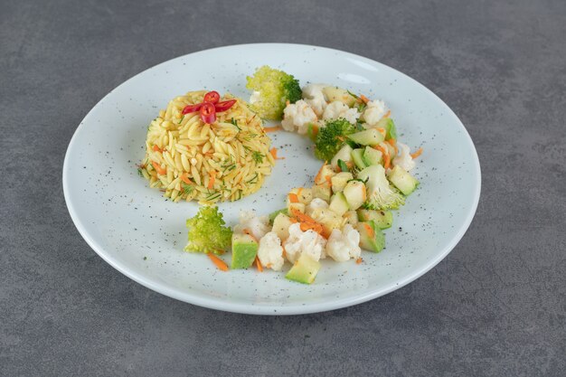 Riz savoureux et légumes sains sur plaque blanche. photo de haute qualité