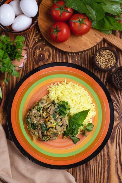 Riz avec viande épinards oeufs tomates épices verts vue de dessus