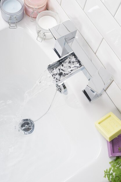 Robinet en acier moderne et neuf avec la baignoire en céramique dans la salle de bain