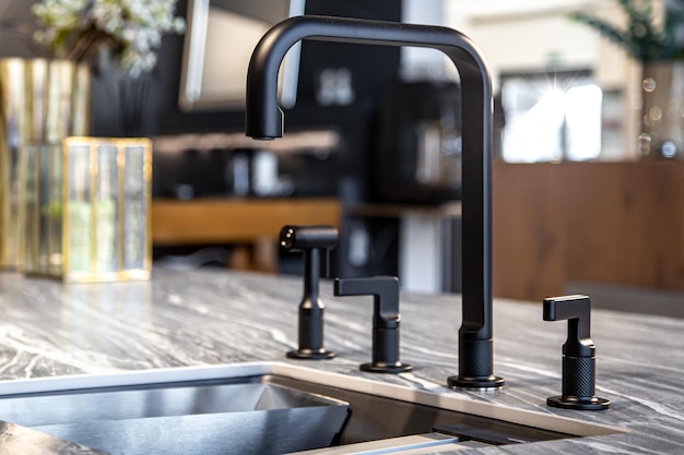 Robinet noir avec un évier en acier dans une cuisine moderne et élégante