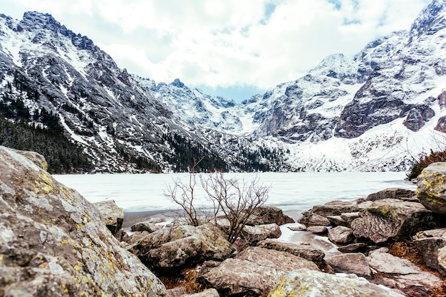 Photo gratuite rocher près du lac et montagne en été