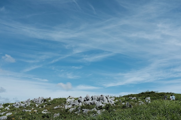 Rochers sur une colline recouverte d'herbe sous un ciel bleu