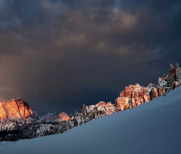 Rochers enneigés à Dolomiten, les Alpes italiennes sous le ciel nuageux sombre