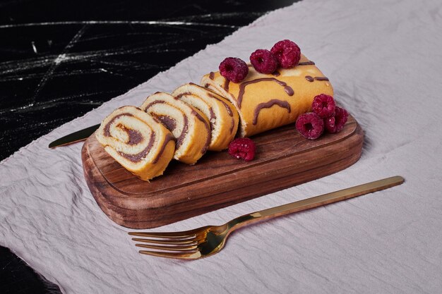 Rollcake aux framboises sur un plateau