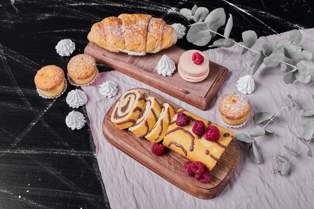 Rollcake aux fruits rouges sur un plateau avec des muffins.