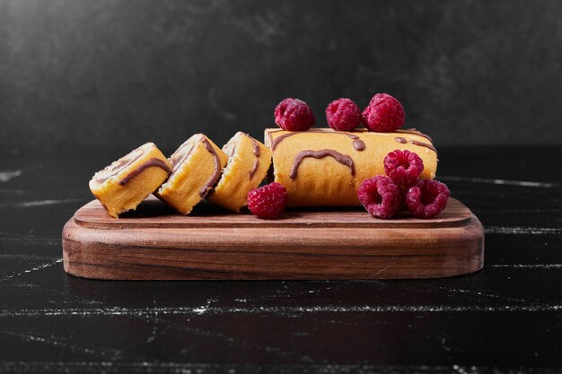 Rollcake aux fruits rouges sur un plateau.