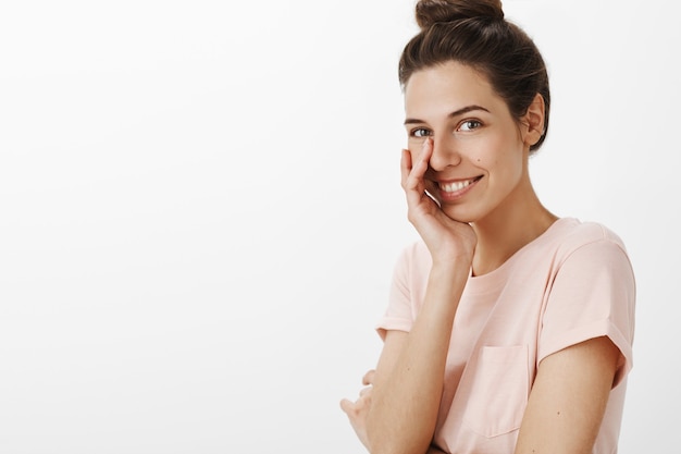 Romantique belle fille posant contre le mur blanc