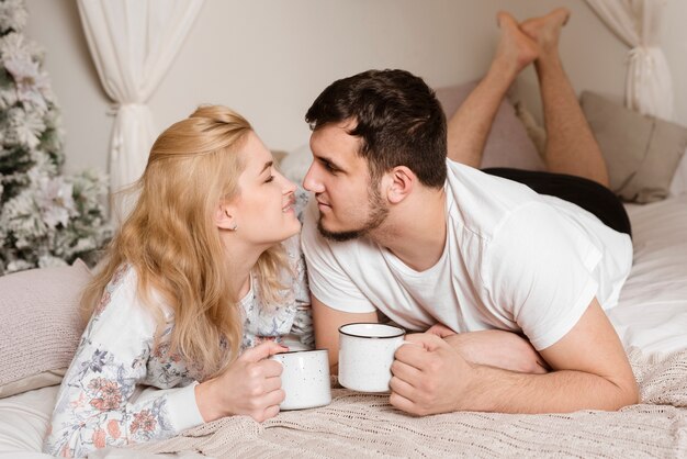 Romantique jeune couple buvant un café au lit