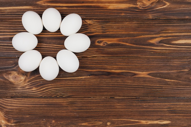 Photo gratuite rond fabriqué à partir d'oeufs blancs sur une table en bois