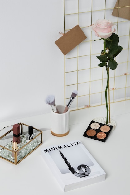 Rose, livre et arrangement de maquillage grand angle