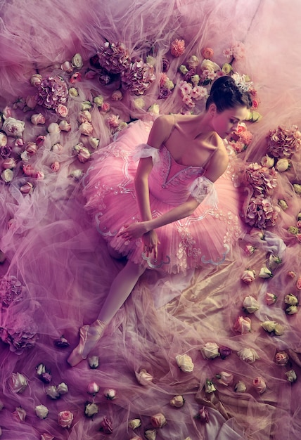 Photo gratuite rose parfait. vue de dessus de la belle jeune femme en tutu de ballet rose entouré de fleurs. humeur printanière et tendresse à la lumière du corail. concept de printemps, de fleurs et d'éveil de la nature.