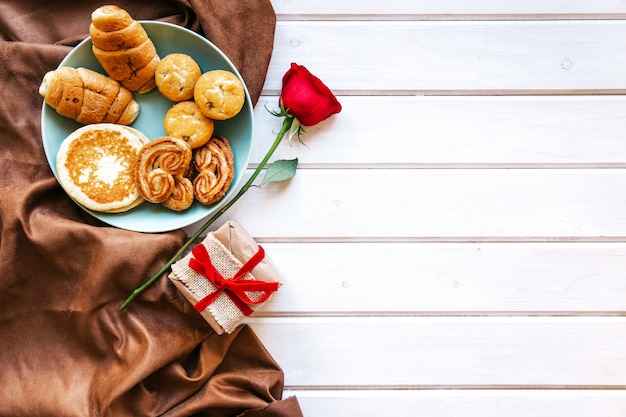 Photo gratuite rose et présent près de la pâtisserie