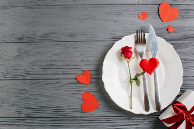 Rose rouge avec des couverts sur une assiette