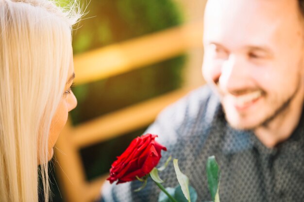 Rose rouge entre le visage du couple