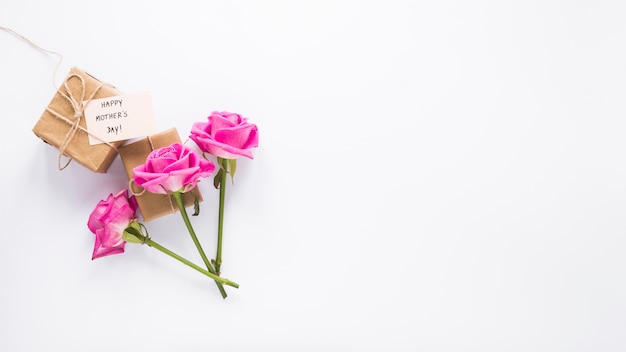 Roses avec des cadeaux et inscription heureuse fête des mères