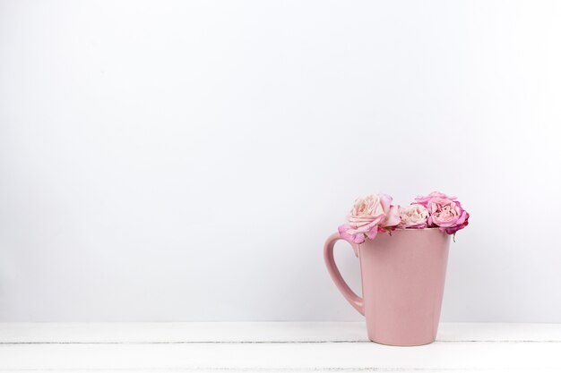 Roses magnifiques roses dans une tasse en céramique à la maison