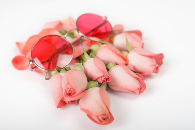 Roses roses avec des lunettes de soleil sur la table