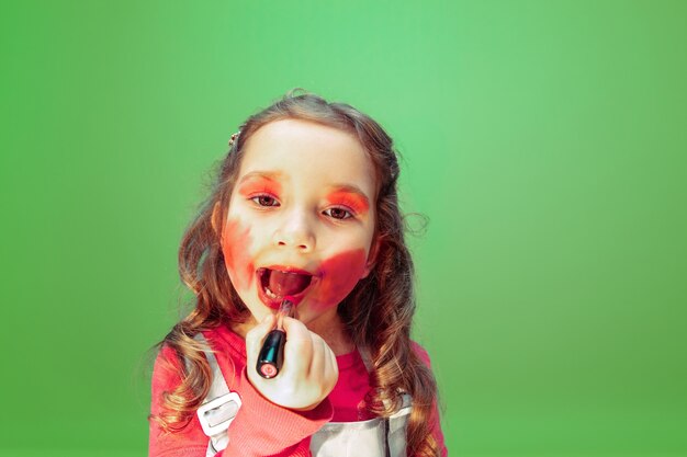 Rouge à lèvres. Petite fille rêvant de profession de maquilleur. Enfance, planification, éducation et concept de rêve. Veut devenir un employé à succès dans l'industrie de la mode et du style, artiste de la coiffure.