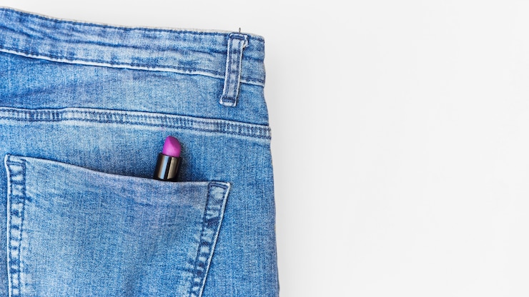 Photo gratuit rouge à lèvres violet dans la poche de jeans sur fond blanc