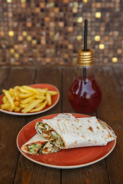 Photo gratuite roulé de poulet au concombre et à la tomate servi avec frites et cocktail au kiwi