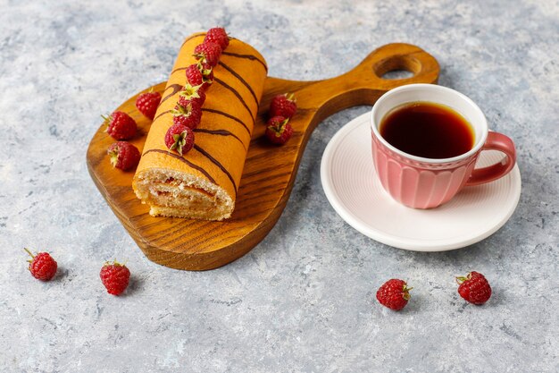 Rouleau de gâteau aux framboises avec des baies fraîches.