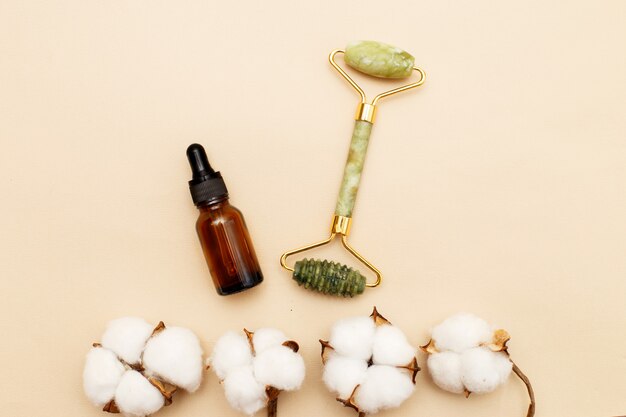 Rouleau de massage en quartz pour le visage de la néphrite naturelle avec de l'huile de sérum avec une fleur de coton