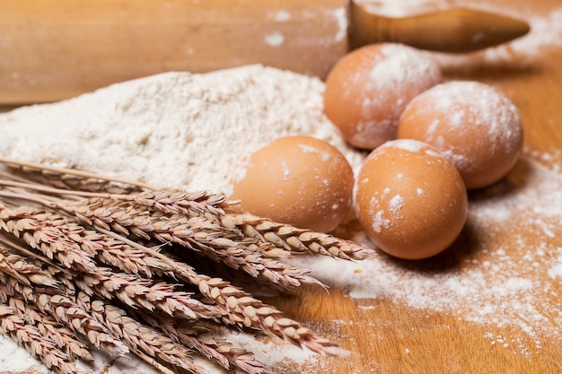 Rouleau à pâtisserie et œufs dans la farine