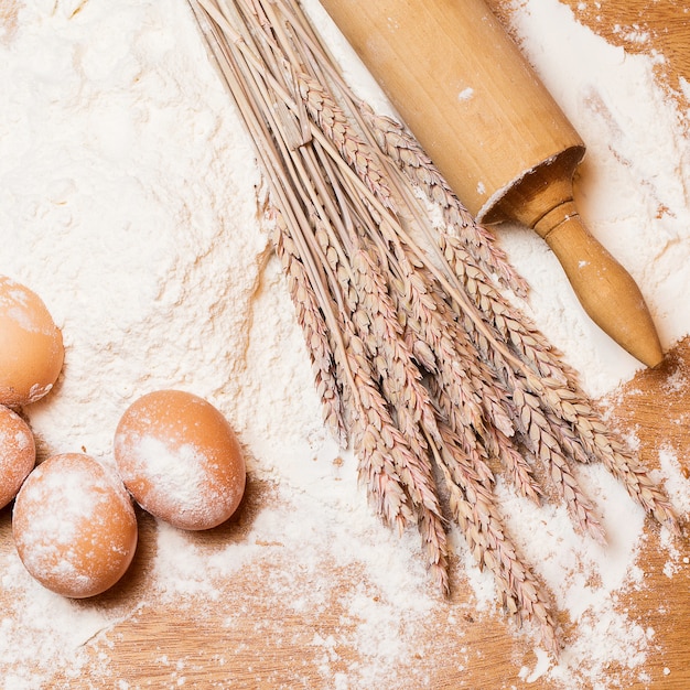 Rouleau à pâtisserie et œufs dans la farine