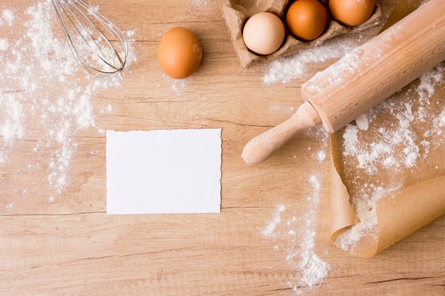 Photo gratuite rouleau à pâtisserie avec oeufs en rack, papier et farine