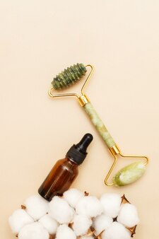 Rouleau de quartz de massage pour le visage de la néphrite naturelle avec de l'huile de sérum dans une bouteille en verre marron