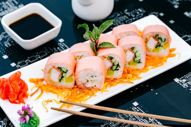 Rouleau de sushi aux bâtonnets de crabe concombre et poivron servi avec sauce soja gingembre et tempura