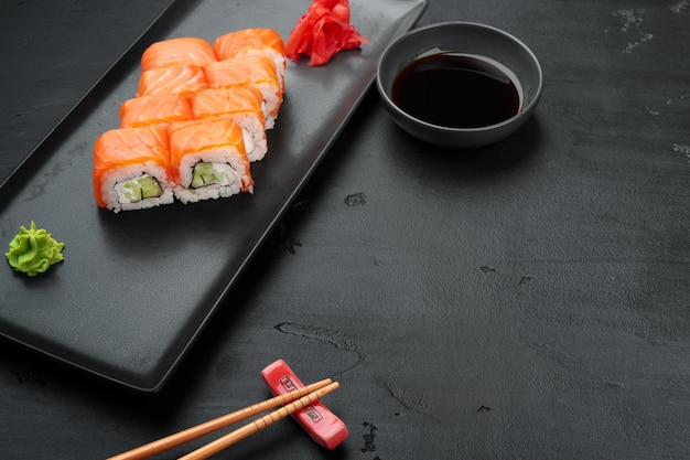 Rouleau de sushi frais de philadelphie servi sur plaque noire