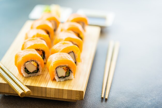 Rouleau de sushi de viande de poisson saumon maki sur plaque de bois