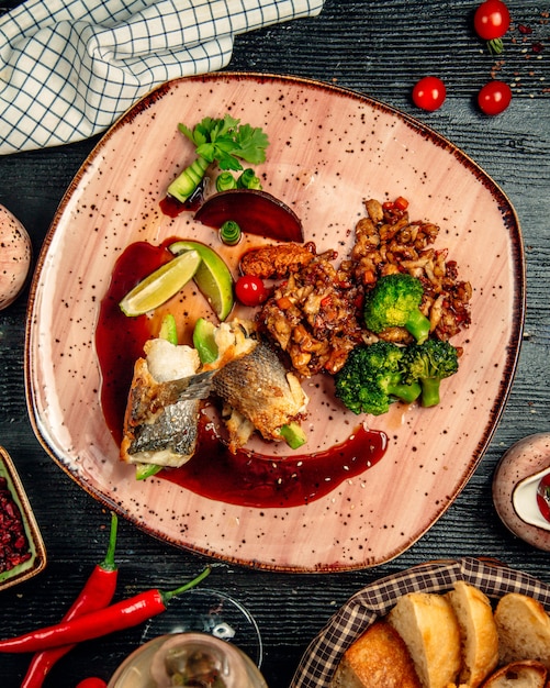 Rouleaux de filet de poulet avec noix et herbes vertes et sauce à l'intérieur de la plaque rouge.