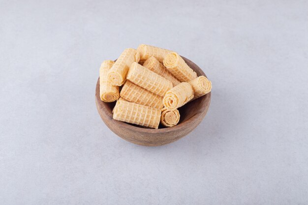 Rouleaux de gaufres dans un bol, sur le marbre.