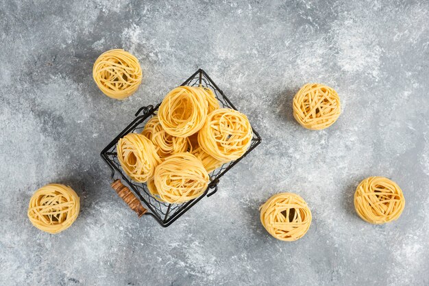 Rouleaux de nouilles non cuits dans un plateau métallique.