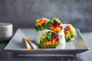 Photo gratuite rouleaux de papier de riz végétalien aux légumes et au sésame servis sur une assiette prête à manger