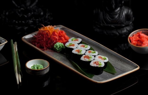 Rouleaux de sushi avec apéritifs dans une assiette grise