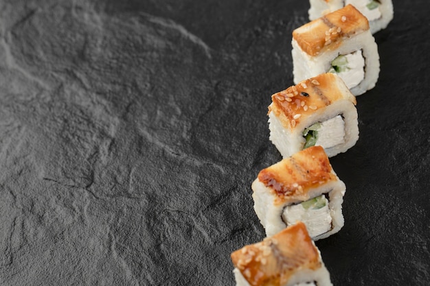 Photo gratuite rouleaux de sushi dragon savoureux avec anguille sur une surface noire