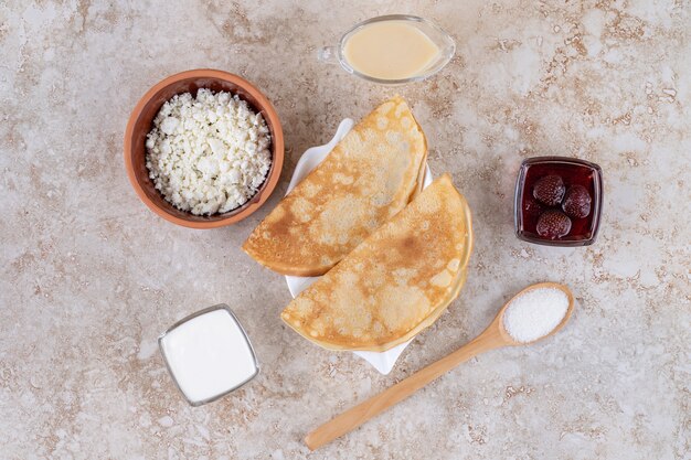 Rouler les crêpes au fromage cottage et à la confiture de fraises